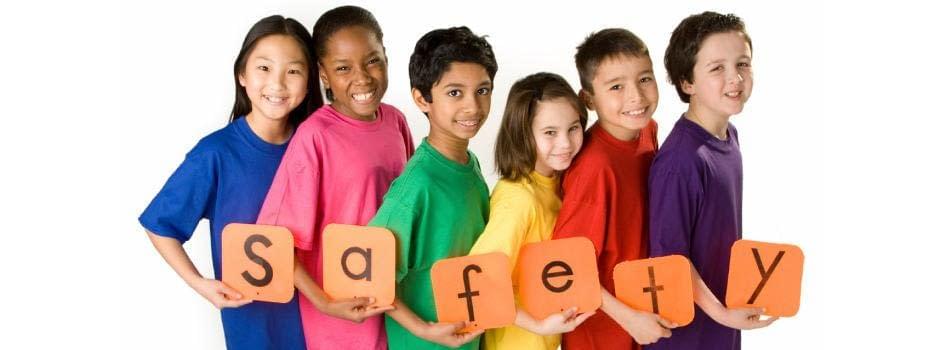 A joyous group of six children, beaming with smiles, are lined up shoulder to shoulder. Each child clutches a vibrant letter, collaboratively spelling out the word "SAFETY." These young ambassadors sport an array of brightly colored shirts: the spectrum includes blue, pink, green, yellow, red, and purple. They stand proudly against a pristine white backdrop with a prominently displayed banner heralding the impeccable services of DFW Airport Transfer in their rear view.