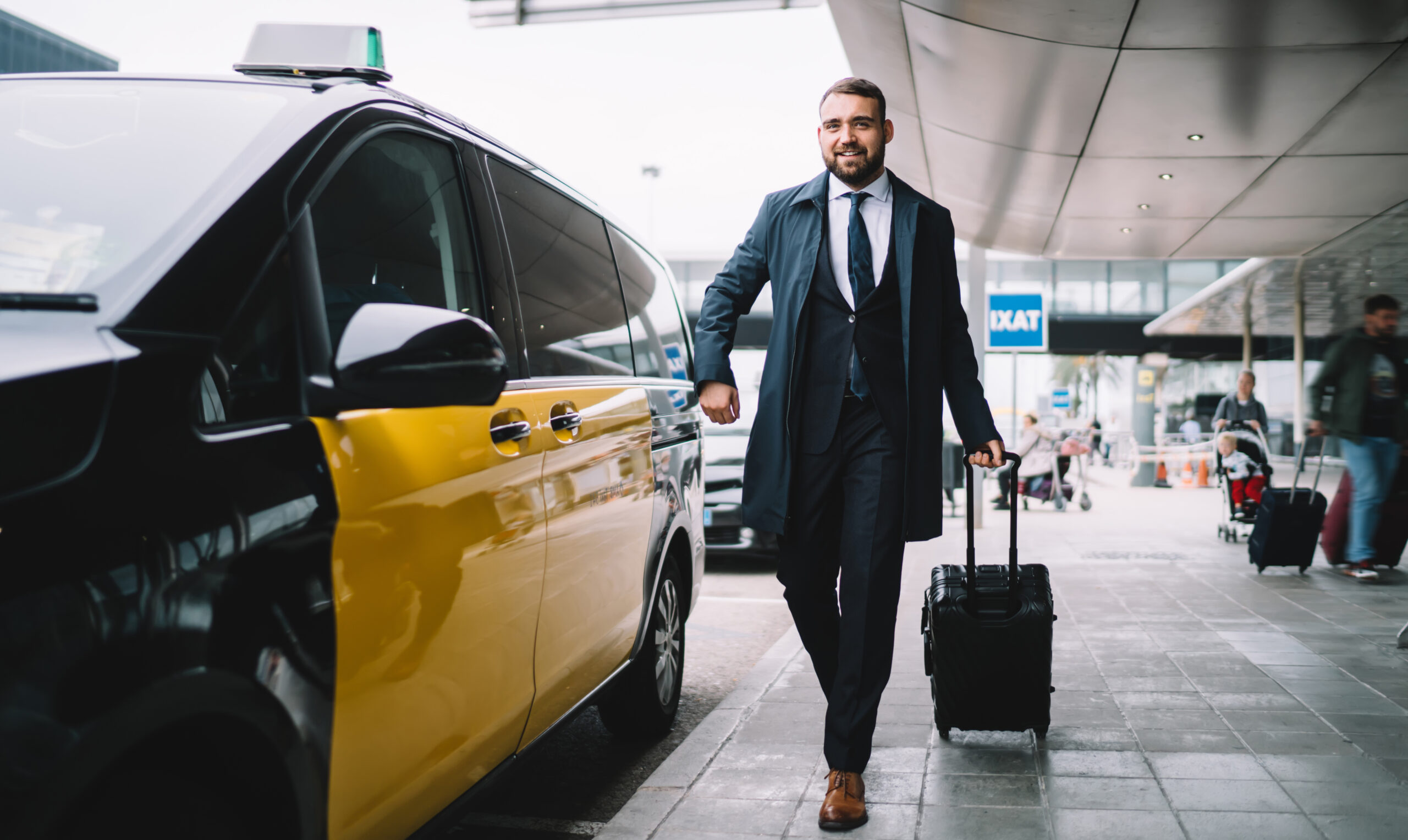 Confident successful businessman in formal wear holding baggage and looking forward while walking to taxi on street near airport terminal